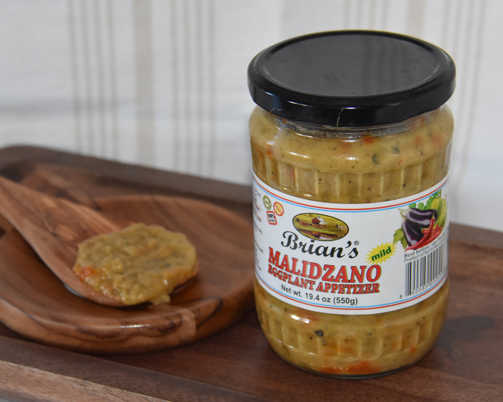 Jar of Brian's Maldzano product on a wooden tray with a wooden spoon.