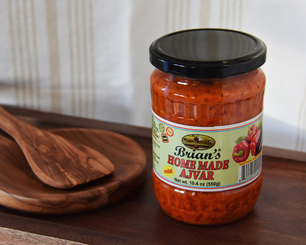 Jar of 'Brian's Homemade Ajvar' on a wooden surface with a blurred background